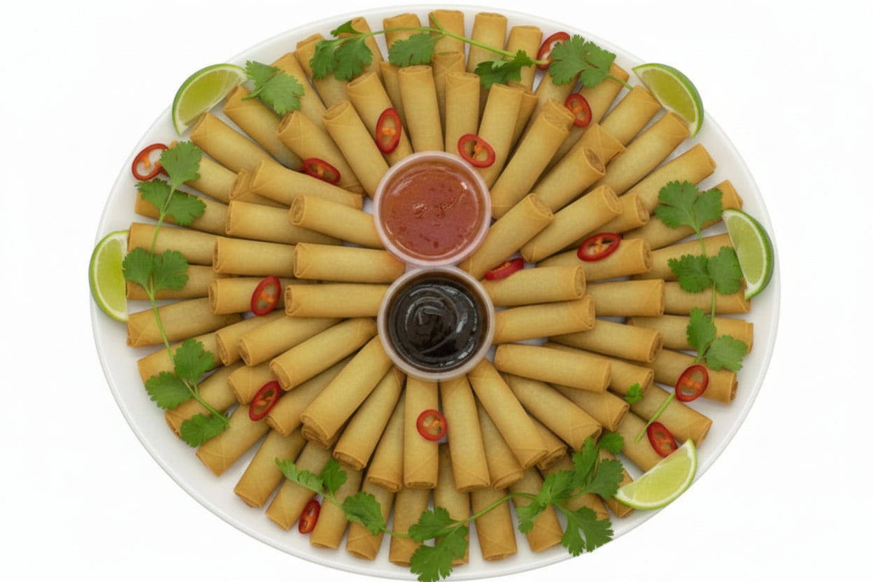 Platter of spring rolls with dipping sauces and garnishes on a white background
